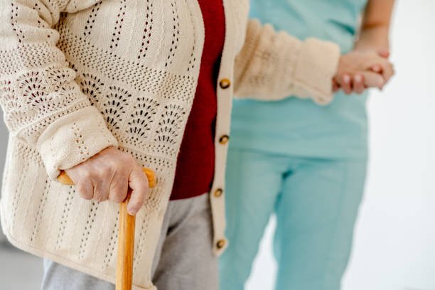 Caregiver supporting an elderly person while walking